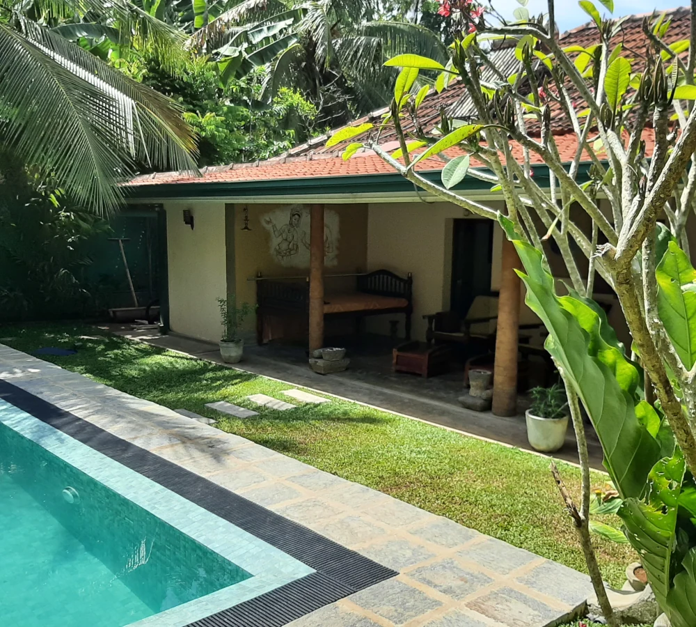 Eingang zum Ayurveda-Zentrum, davor der Pool im Garten
